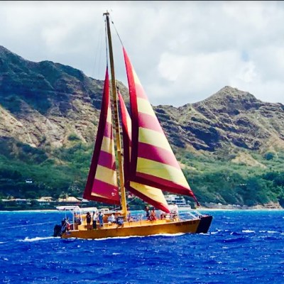 a small boat in a body of water with a mountain in the background