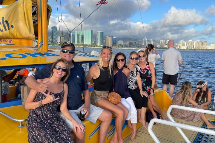 Group of people on a boat with city skyline in the background.